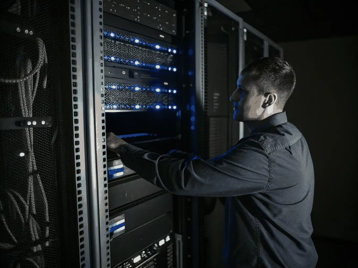 A professional IT technician configuring network switches and servers in a modern, well-lit data center, representing hands-on network infrastructure management for business clients.